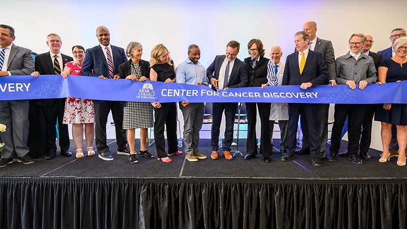People participating in a ribbon cutting for the Medical College of Wisconsin Center for Cancer Discovery grand opening