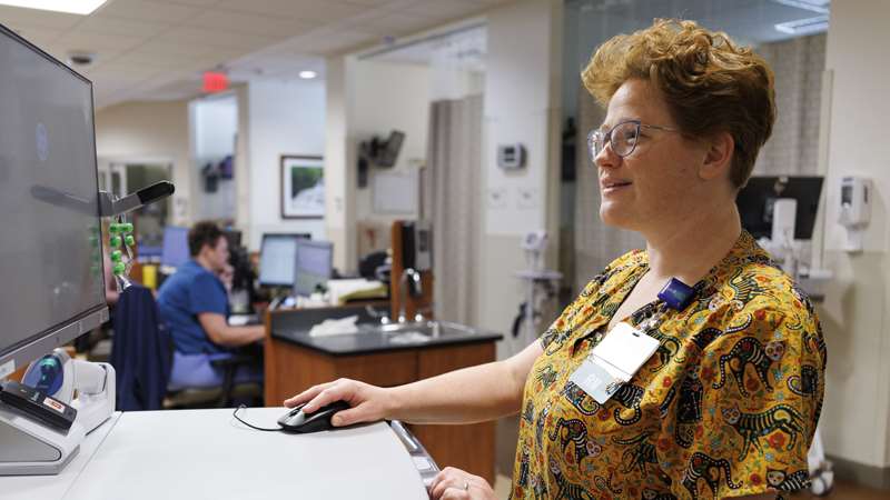 Medical professional looking at computer display in the Nicholas Family Foundation Translational Research Unit 