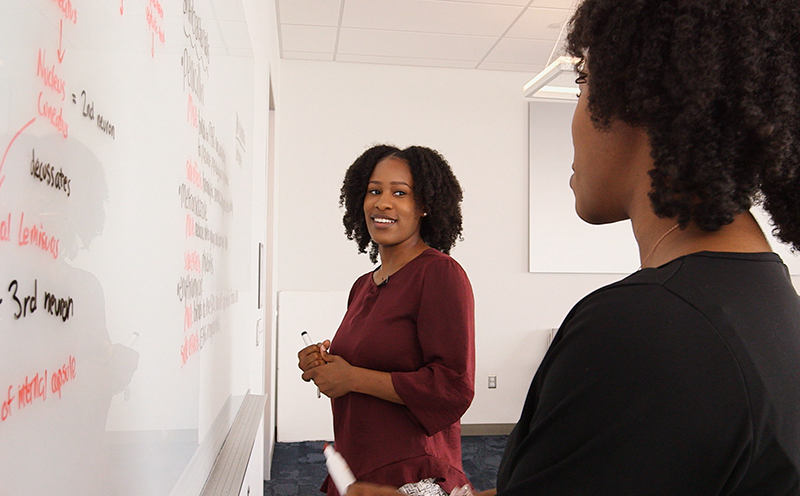 Two women standing at a whiteboard