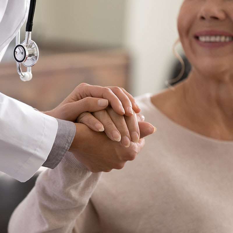 physician holding hands with patient