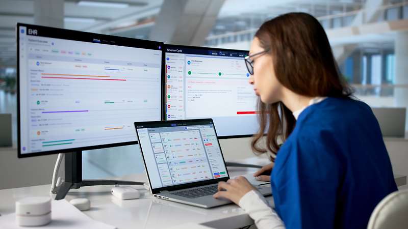 Woman viewing data on computer screens