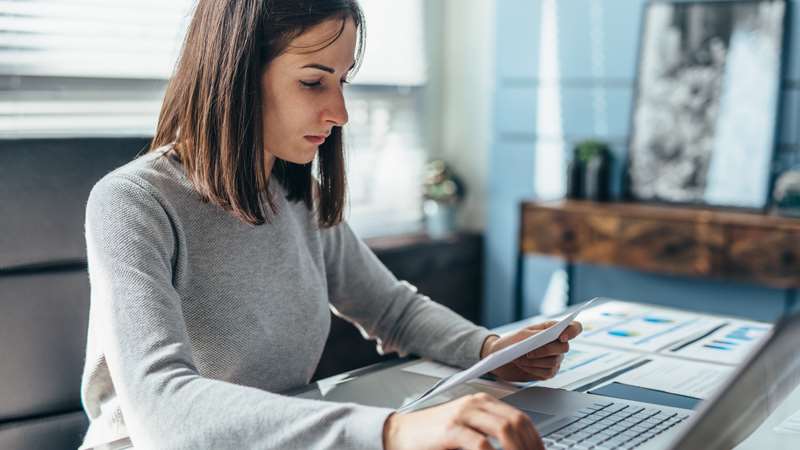 Woman at desk viewing paragraph and typing on keyboard