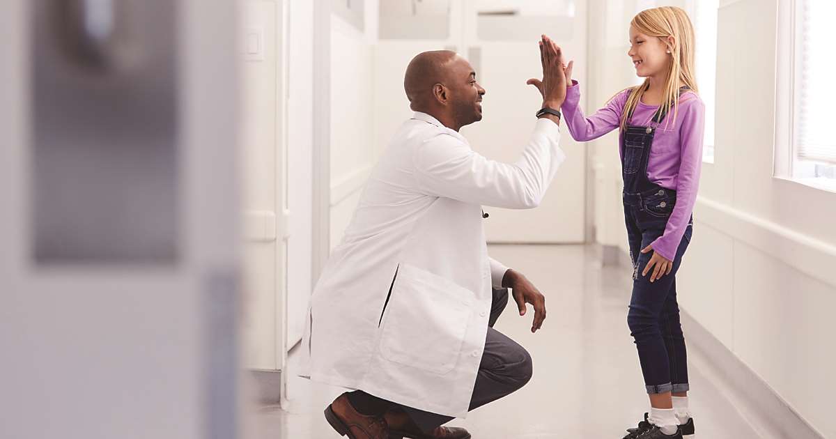 Doctor high fiving young girl