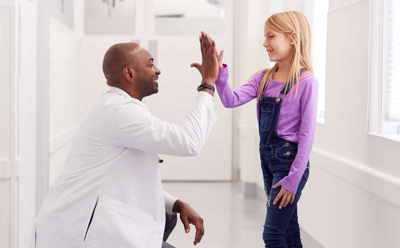 Doctor high-fiving a pediatric patient