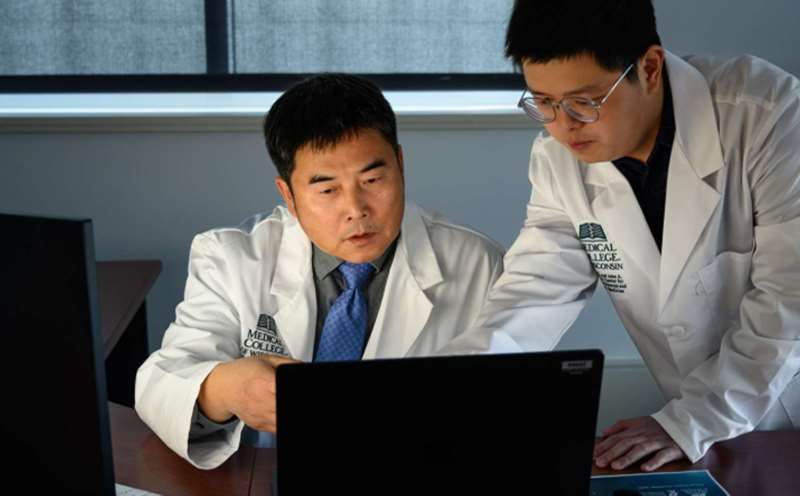 Dr. Xiaowu Gai and another researcher looking at a computer screen